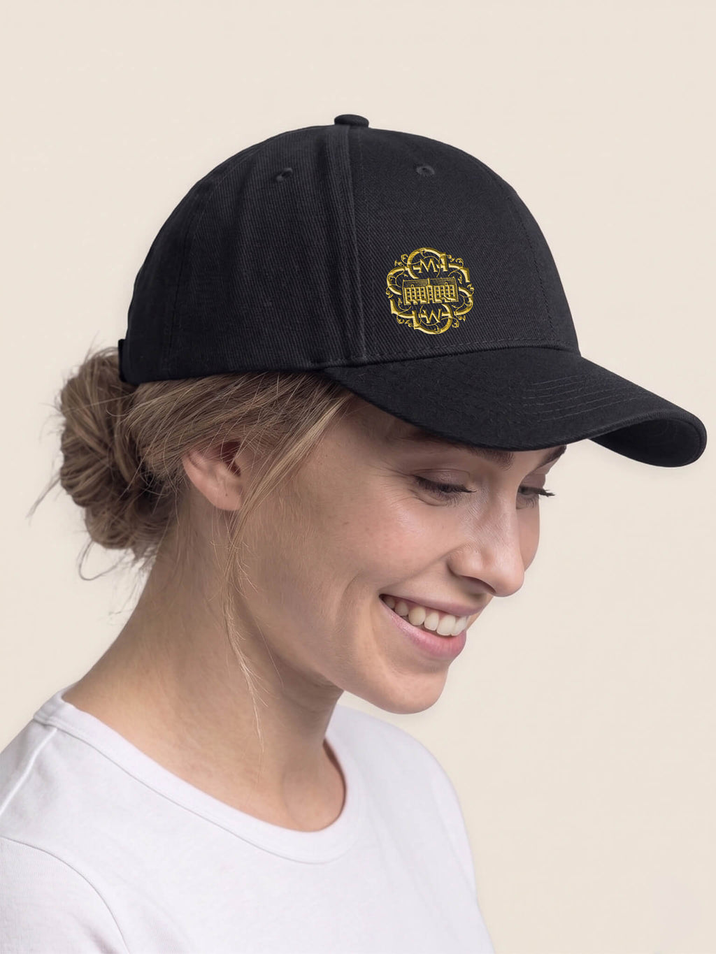 Woman wearing a black Scottish Malt Whisky Society baseball cap with goldlogo on the front right panel.