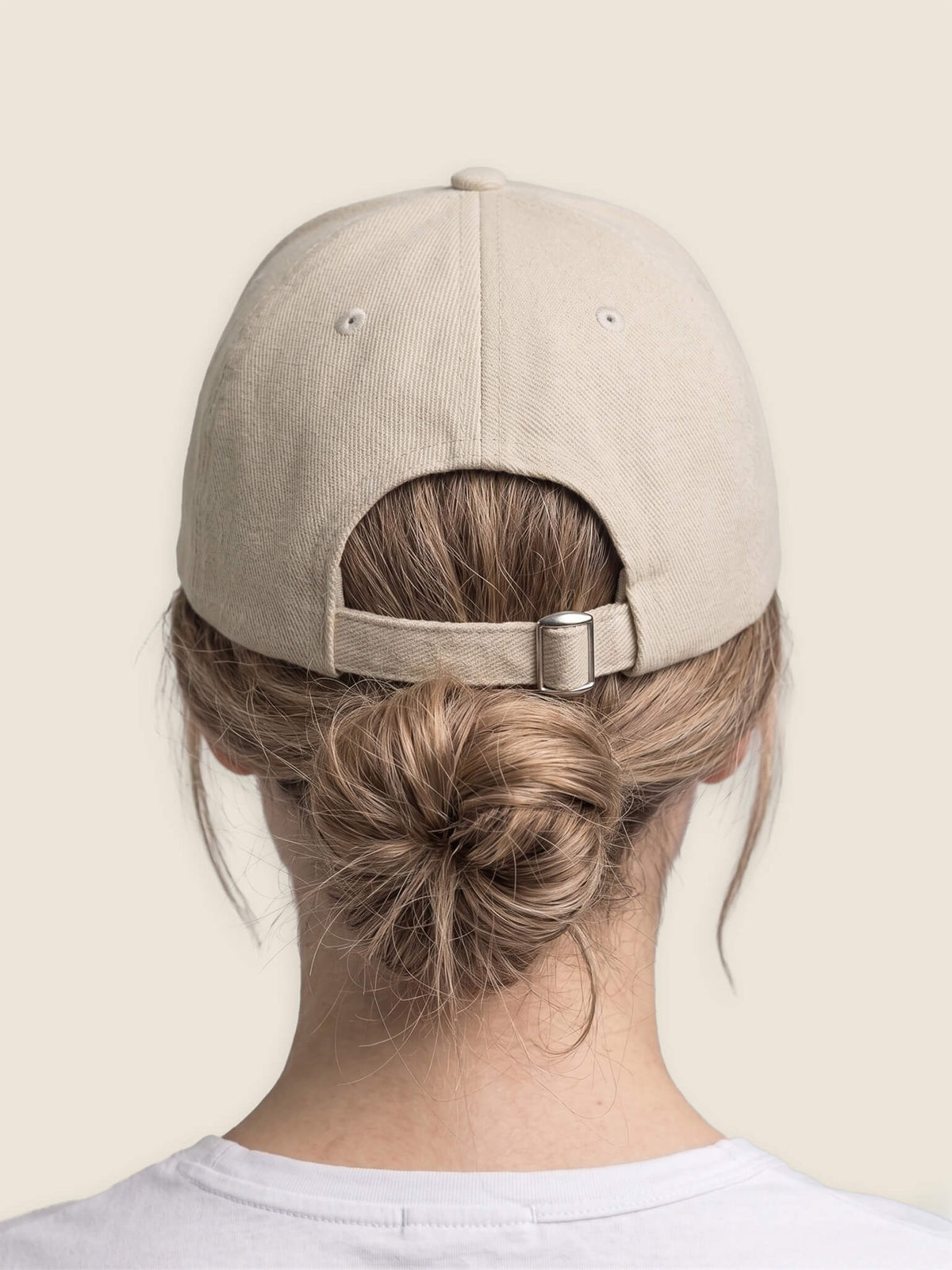 Back view of woman wearing a stone Scottish Malt Whisky Society baseball cap showing tri-glide size adjuster.