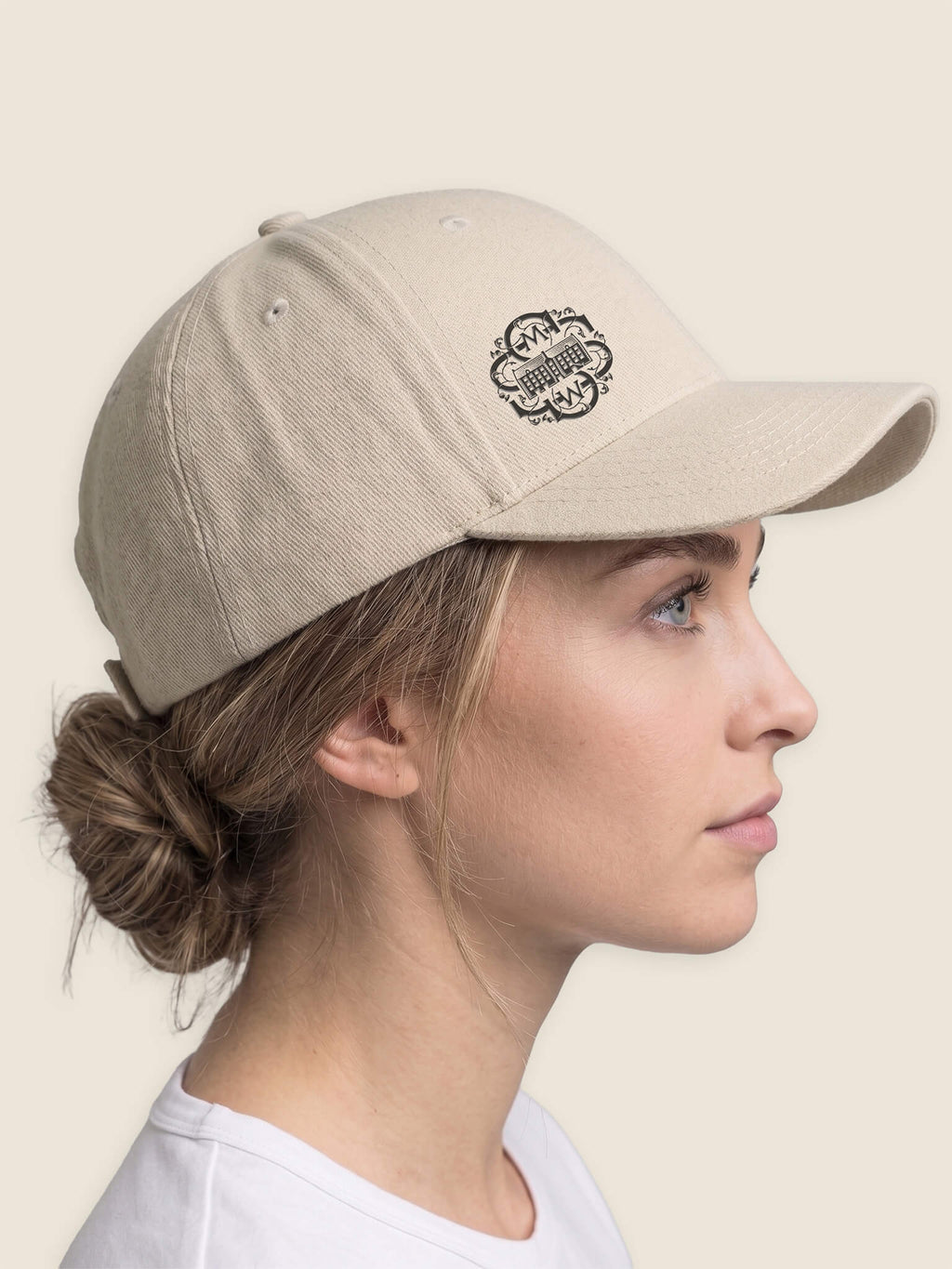 Side view of woman wearing a stone Scottish Malt Whisky Society baseball cap with black logo on the front right panel.
