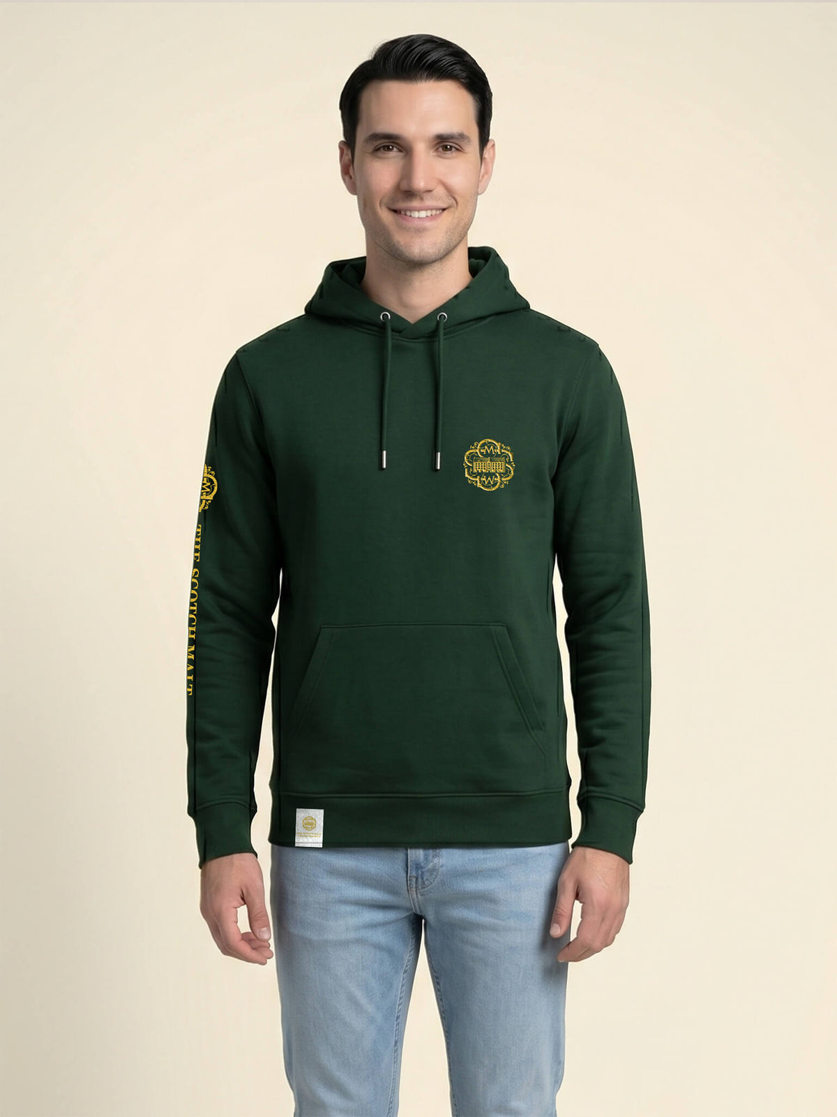 Man wearing a forest green Scottish Malt Whisky Society hoodie with gold logo on the left chest.