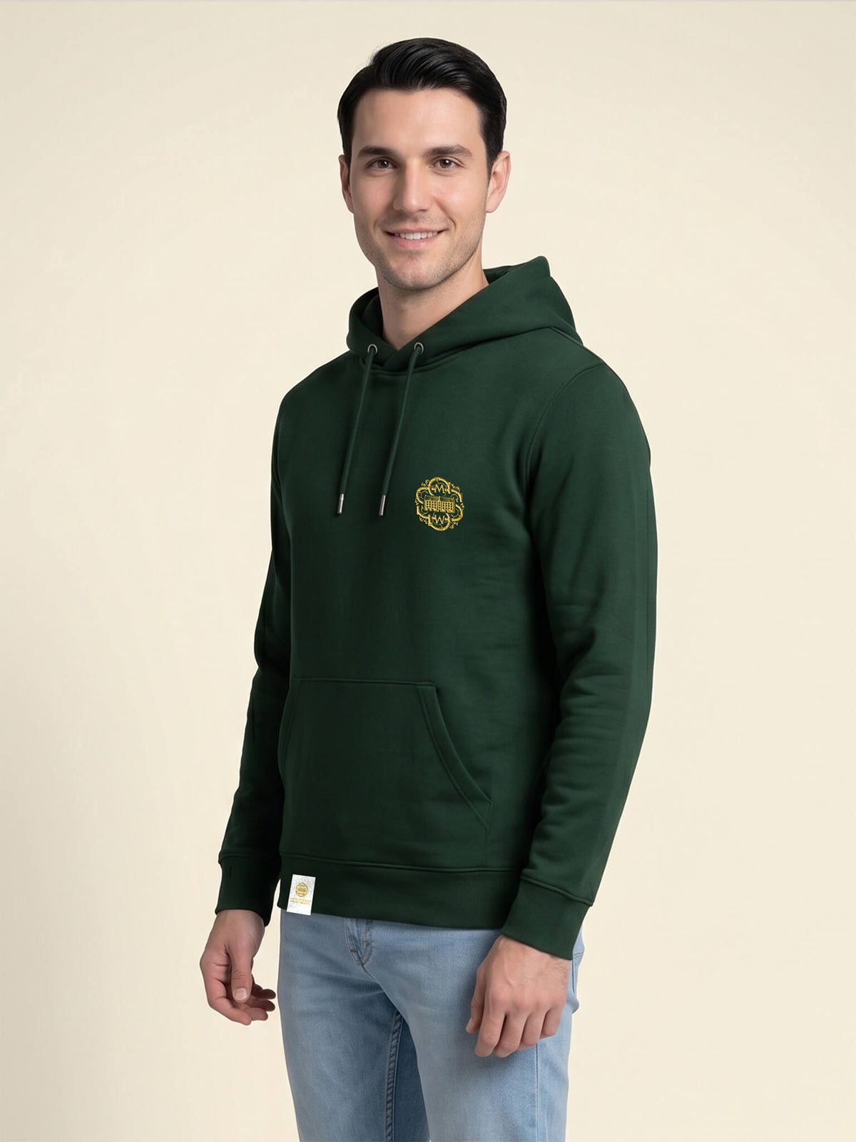 Side view of a man wearing a forest green Scottish Malt Whisky Society hoodie with gold logo on the left chest.