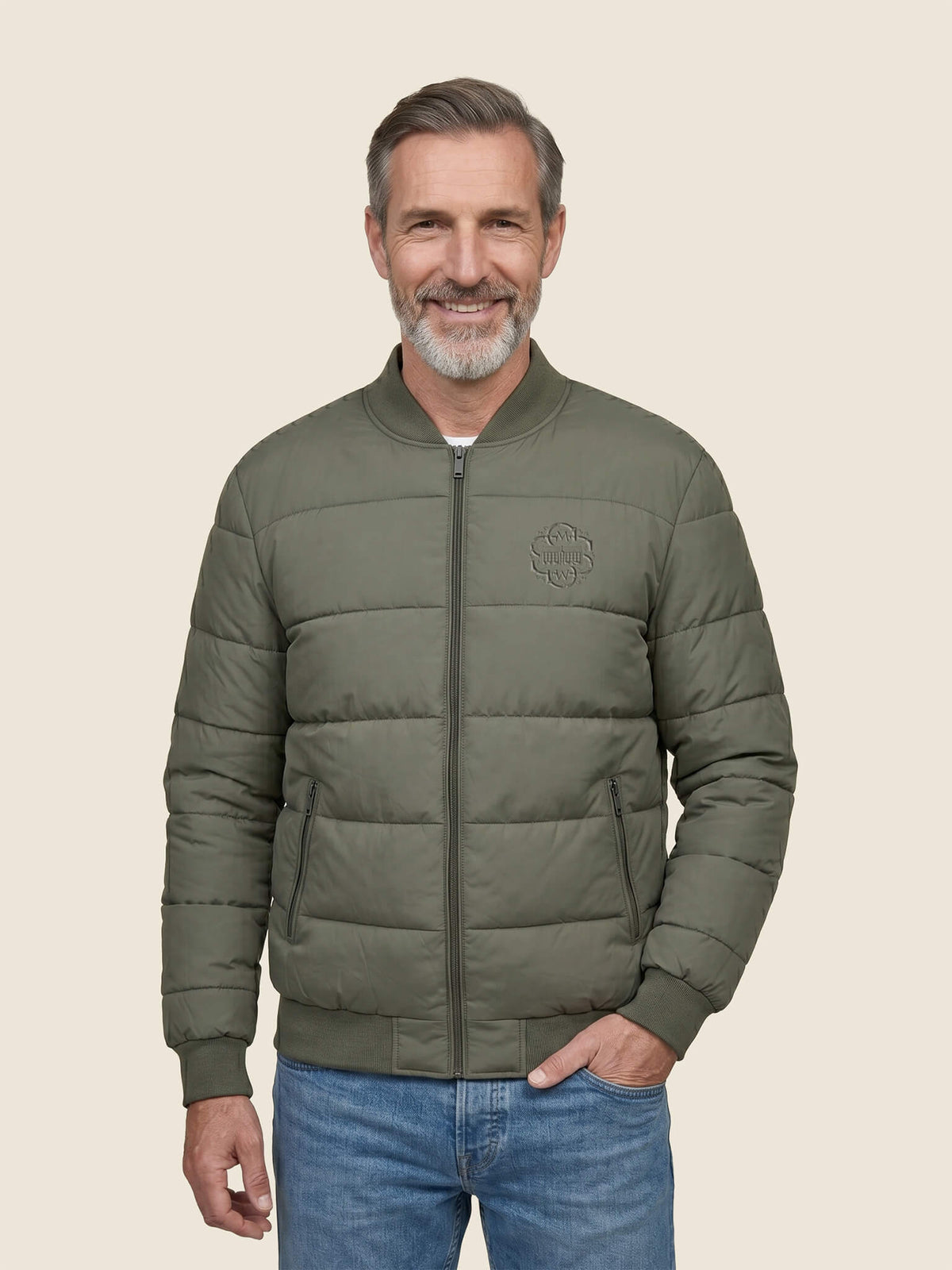 Man wearing a khaki Scottish Malt Whisky Society padded jacket with tone on tone logo on the left chest.