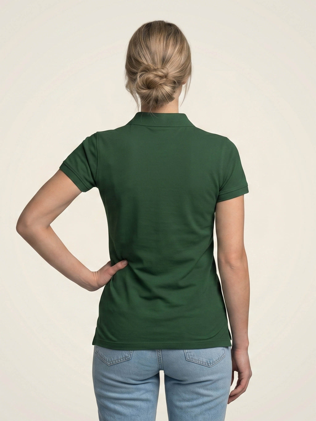 Woman wearing forest green SMWS fitted polo shirt.