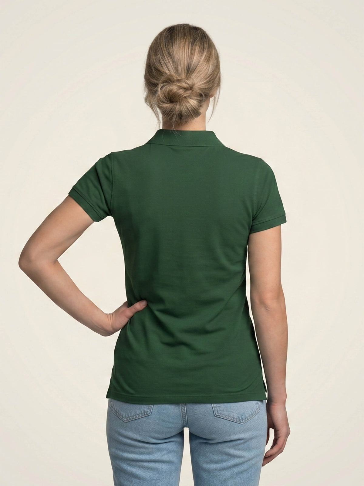 Woman wearing forest green SMWS fitted polo shirt.