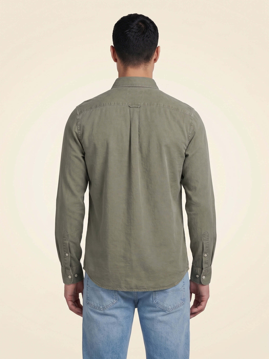 Back view of man wearing a washed pale Khaki organic cotton shirt