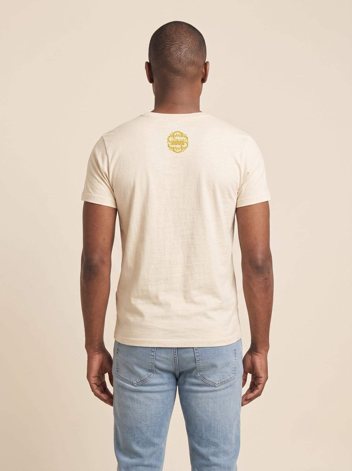 Back view of man wearing ivory Signature  T-shirt with SMWS monogram on the back of the neck.