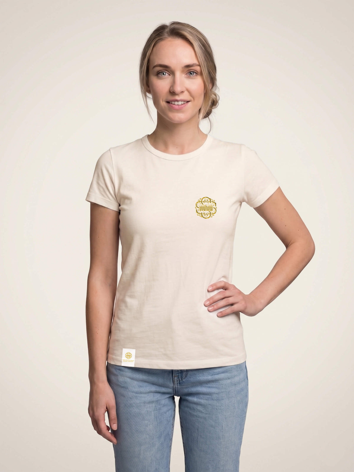 Woman wearing an ivory Scottish Malt Whisky Society t-shirt with gold logo on the left chest.